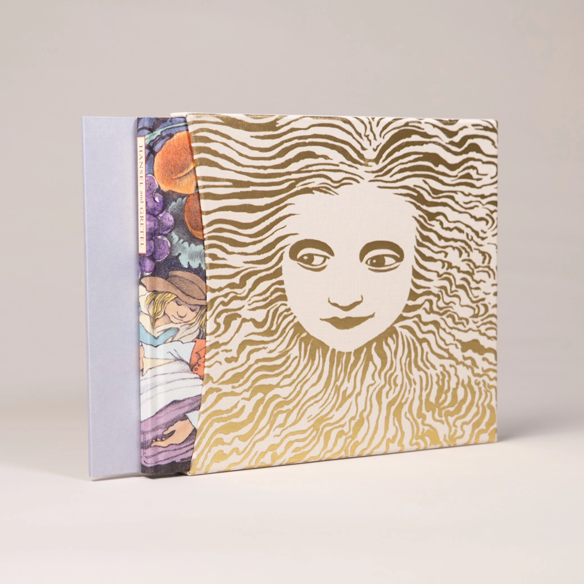The slipcase of Hansel and Gretel featuring a gold foil sun design